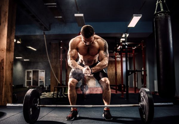 Foto Premium | Hombre musculoso preparándose para levantar peso muerto con  una barra sobre su cabeza en el moderno gimnasio. entrenamiento funcional.